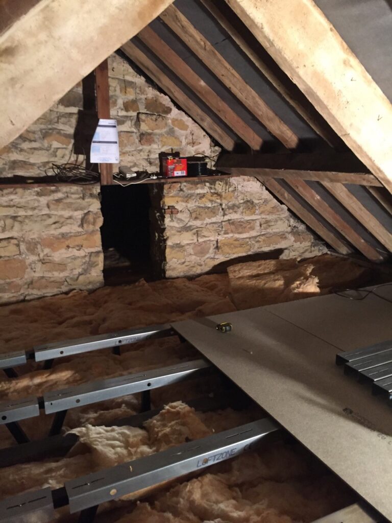 old brick house getting loft boarding installed in the attic