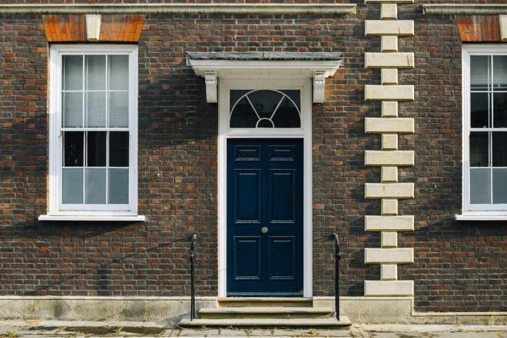 exterior view british townhouse with a navy front door